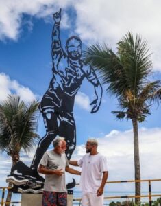 Ítalo Ferreira e Guaracy Gabriel em frente à estátua em Baía Formosa