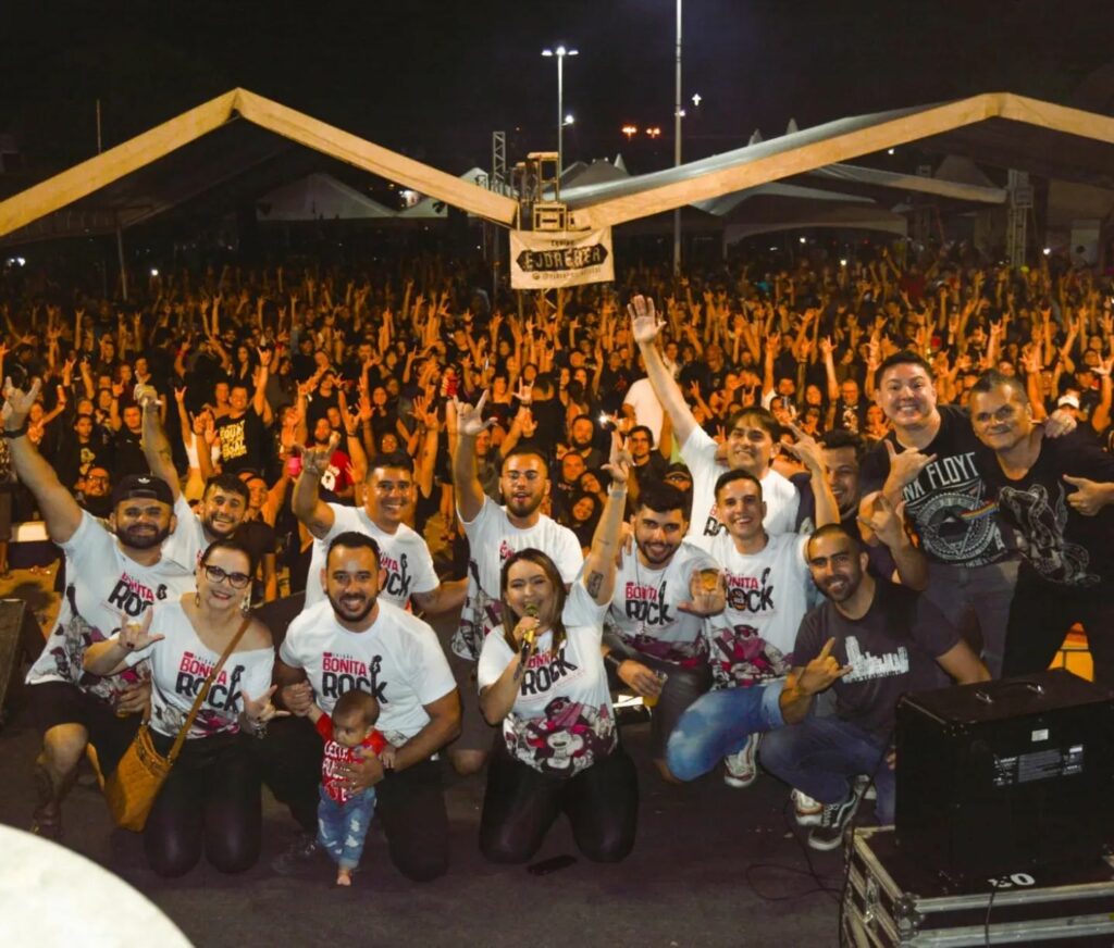 Equipe do Bonita Rock no palco com público ao fundo